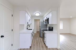 Redmond apartment for rent - Renovated kitchen with white cabinets and black fridge at Melrose on 91 in Redmond, WA