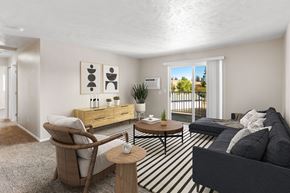Post Falls apartment for rent - A living room with a grey couch, a wooden chair, and a coffee table at The Overlook Apartments in Post Falls, ID.