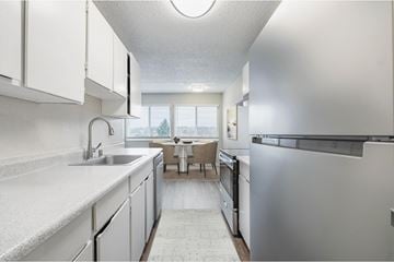 Renton apartment for rent - A modern kitchen with white cabinets and stainless steel appliances.