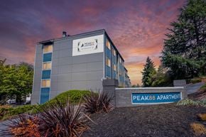 Renton apartment for rent - The image shows a building with the sign "Peak88 Apartments" in front of it.