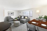Billings apartment for rent - A modern living room with grey furniture and a wooden dining table at Rock Creek Apartments in Billings, MT.