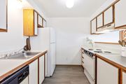 Billings apartment for rent - A double galley kitchen with white appliances and wooden cabinets at Shiloh Glen Apartments in Bilings.