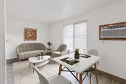 Billings apartment for rent - A dining room with a white table and chairs that opens to a living room at our Billings Apartments in Montana.