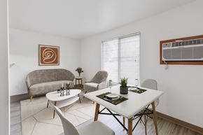 Billings apartment for rent - A dining room with a white table and chairs that opens to a living room at our Billings Apartments in Montana.