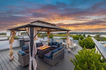 Seattle apartment for rent - A wooden deck with a canopy and chairs is set up for outdoor seating.