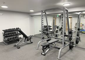 University Place apartment for rent - Fitness center with weight rack, free weights, squat, bench press rack, and two benches at University Glen, University Place, Washington