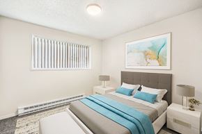 Kennewick apartment for rent - Spacious bedroom with white walls, taupe carpets, and a large window with white blinds. Staged with a bed, side tables, a bench, and art.at Wildflower, Washington, 99336