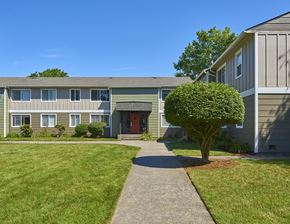 Everett apartment for rent - Exterior grounds with paved pathway leading through large grass area to homes.at Woodhaven, Everett, Washington