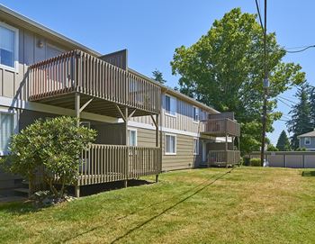 A row of houses with balconies on the side of a yard