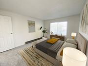 Twin Falls apartment for rent - Bedroom with white walls, oversized window with natural light, gray carpet, staged with bed, side tables, dresser, and plant.at Laurel Park, Twin Falls, 83301