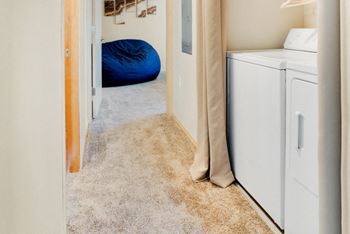 A washer and dryer in a laundry room with a blue pillow in the