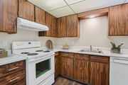 Moses Lake apartment for rent - Kitchen with warm wood cabinets, white electric range, and ample counter space at The Lakes Apartments