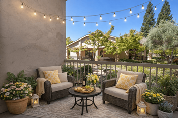 Private balcony seating area with string lights
