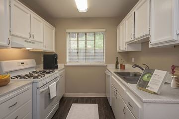 Auburn apartment for rent - A kitchen with white cabinets and a black stove top.