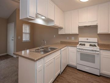 Lodi apartment for rent - A kitchen with white cabinets and a white stove top oven.