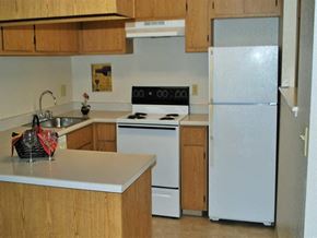 Ranch Cordova apartment for rent - A white stove and oven in a kitchen with wooden cabinets.
