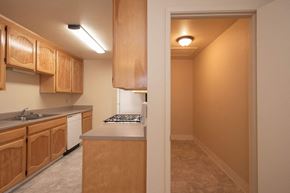 Atwater apartment for rent - Galley kitchen with wood cabinets and pantry entrance at Castle Vista Senior Duplex Community Apartments, California, 95301