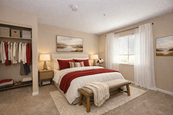 Bedroom with walk-in closet and red bedding accents
