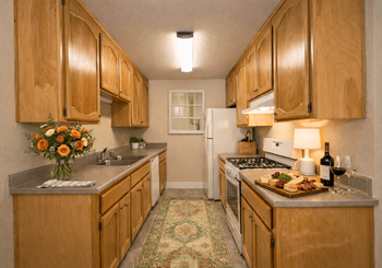 Galley kitchen with wood cabinets and gray countertops