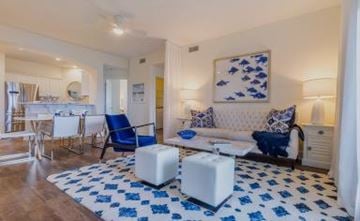 Gulf Shores apartment for rent - A living room with blue and white furniture and a large painting on the wall.