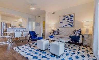 Gulf Shores apartment for rent - A living room with blue and white furniture and a large painting on the wall.