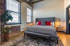 Denver apartment for rent - Industrial Style Apartment Bedroom with Windows, Bed, Nightstand and Plants
