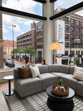 Cincinnati apartment for rent - A grey couch with a small table in front of it.