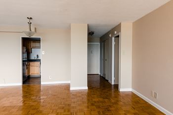 An empty living room with a hard wood floor and white walls