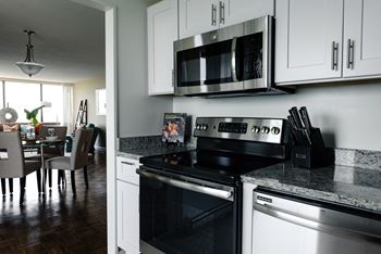 A modern kitchen with a stove top oven and microwave above it.