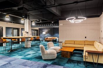 A lobby with couches chairs and tables and a bar
