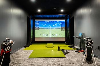 A training room with a screen in the center of the room and two cameras on