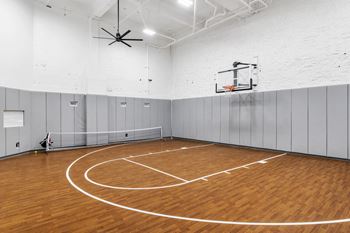 The gym has a hardwood floor and a basketball hoop