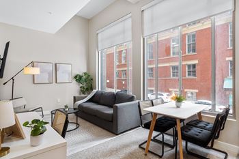 A living room with large windows and a couch and a table