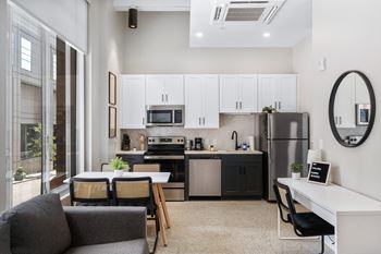 An open kitchen and living room with a table and chairs