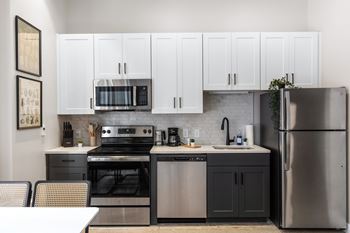A kitchen with stainless steel appliances and white cabinets