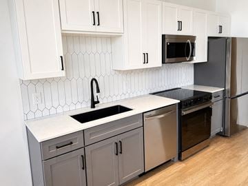 Cincinnati apartment for rent - A kitchen with white cabinets and a black sink.