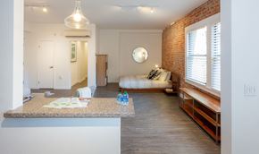 Hollywood apartment for rent - A kitchen with a counter and a bedroom with a bed.