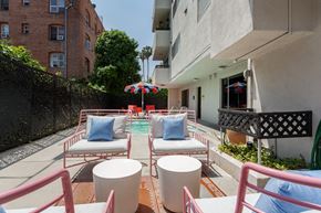 Los Angeles apartment for rent - a patio with chairs and tables and a pool
