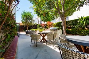 Los Angeles apartment for rent - Outdoor Lounge and BBQ Area With Patio Chairs, Tables, and Lush Landscaping