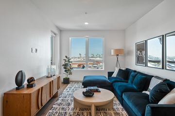 Gardena apartment for rent - A living room with a blue couch and a wooden cabinet.