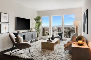Los Angeles apartment for rent - A living room with a chair, a table, a television, and a view of the city.