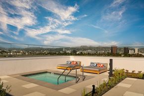 Los Angeles apartment for rent - a rooftop terrace with a pool and two chairs and a city in the background