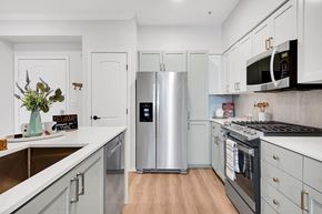 Woodland Hills apartment for rent - a kitchen with white cabinets and stainless steel appliances