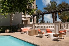 Woodland Hills apartment for rent - a patio with chairs and a table next to a pool
