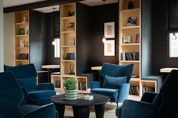 Burbank townhouse for rent - A living room with blue chairs and a table with a plant on it.