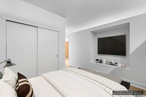 Berkeley apartment for rent - A modern bedroom with a large bed and a flat screen TV mounted on the wall.