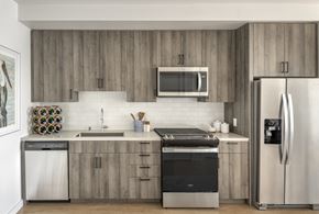 Oakland apartment for rent - a modern kitchen with stainless steel appliances and wooden cabinets