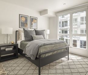 Oakland apartment for rent - a bedroom with a bed and two windows