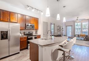 Mckinney apartment for rent - a kitchen with a island and a stainless steel refrigerator at Discovery at Craig Ranch, McKinney