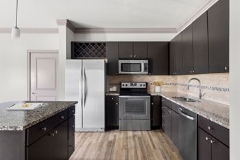 Modern kitchen with dark cabinets and granite countertops